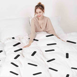 Therapy blanket and bedding set with black stripes.