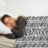 Therapy blanket and bedding set with black shapes.