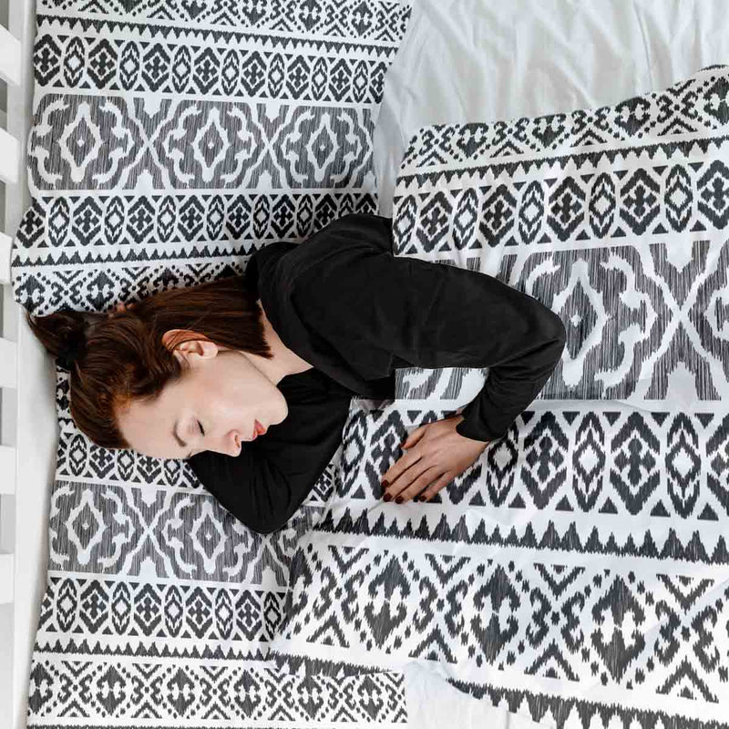 Therapy blanket and bedding set with black shapes.